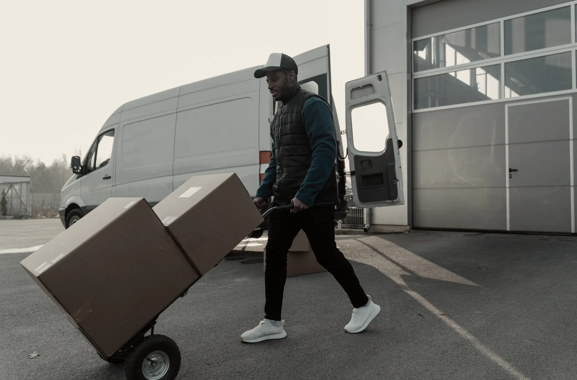 Cargo van loaded at a warehouse dock with a hand truck