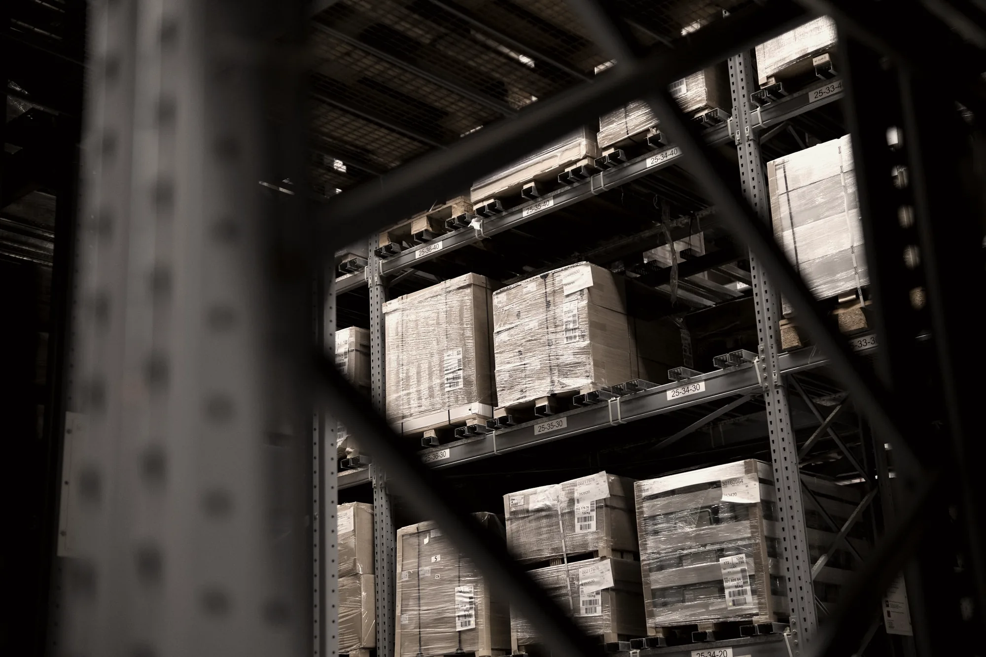 Shrink-wrapped and labelled pallets in warehouse racking